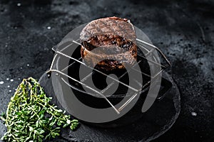 Fillet Mignon grilled beef Steak on a grill. Black background. Top view