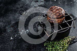 Fillet Mignon grilled beef Steak on a grill. Black background. Top view. Copy space