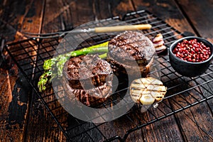 Fillet Mignon grilled Steak with asparagus, beef tenderloin meat. Wooden background. Top view