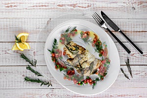 Fillet of zander, rosemary, thyme, lemon and vegetables on a plate in a restaurant. top view