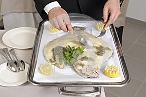 Filleting a poached turbot photo