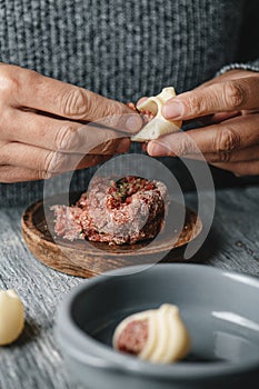 is filling a Catalan galet with raw ground meat photo