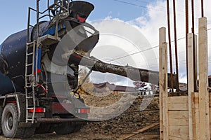 Filling concrete from mixer into wooden formwork