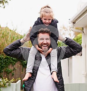 Filling the day with endless joy. Portrait of father carrying his little daughter on his shoulders.