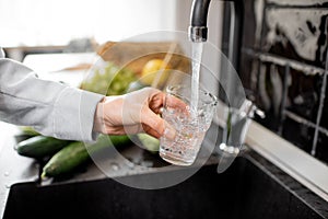 Filling drinking glass with tap water