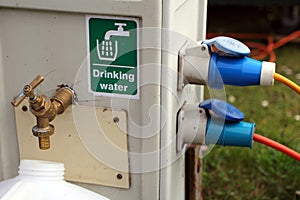 Filling a drinking water container at a campsite water and electricity supply point