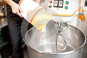 Filling flour into the kneader at the bakery