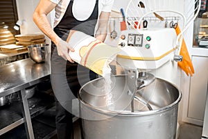Filling flour into the kneader at the bakery