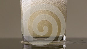 Filling glass with soda water in slow motion. Stock footage. Close up of pouring soft drink with many bubbles inside the