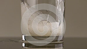 Filling glass with soda water in slow motion. Stock footage. Close up of pouring soft drink with many bubbles inside the