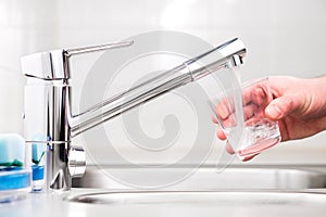 Riempimento bicchiere approfittare di Acqua. rubinetto un il lavandino 