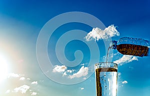 Filling of a glass by water against the sky