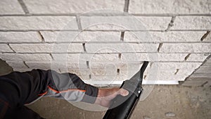 Filling the joints between bricks on the facade of the house. Poor quality brickwork. Cement joints between masonry