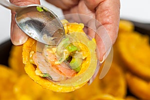 Filling a plantain cup with shrimp ceviche