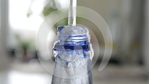 Filling a Plastic Bottle with Fresh Water. Making Water Reserve in a Recipient. Water Economy Concept.