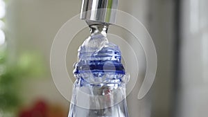 Filling a Plastic Bottle with Fresh Water. Making Water Reserve in a Recipient. Water Economy Concept.