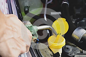 Filling the tank of windshield washer fluid