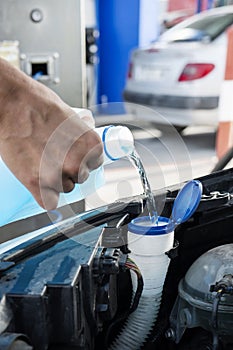 Filling the tank of windshield washer fluid