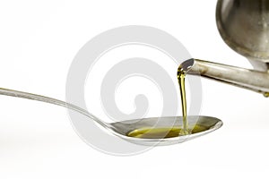 Filling up a tablespoon of extra virgin olive oil from a cruet photo
