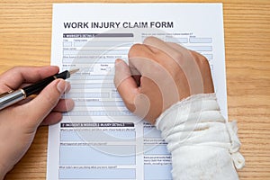 Filling up a work injury claim form with a wrapped hand