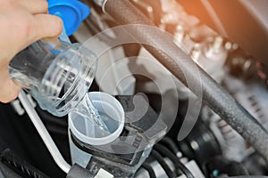 Filling the Windshield Washer Fluid in the Car. Automobile Maintenance Concept