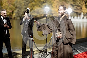 Film actor with photographers on the red carpet outdoors