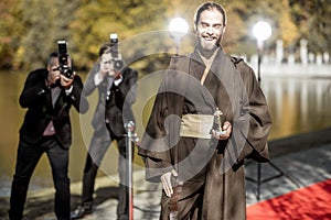 Film actor with photographers on the red carpet outdoors