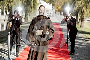 Film actor with photographers on the red carpet outdoors