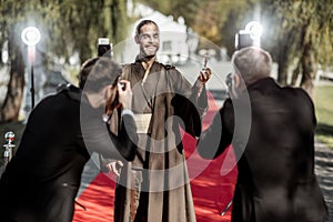 Film actor with photographers on the red carpet outdoors