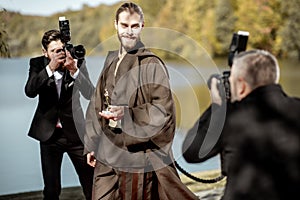 Film actor with photographers on the red carpet outdoors