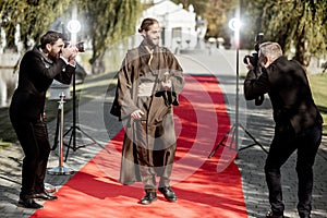 Film actor with photographers on the red carpet outdoors