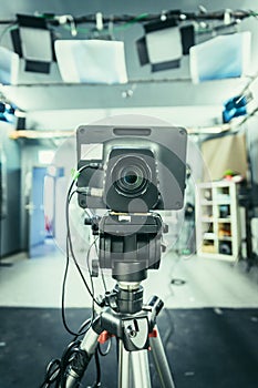 Film camera in broadcasting studio, spotlights and other equipment