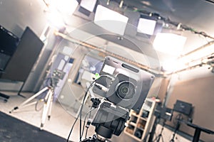 Film camera in broadcasting studio, spotlights and other equipment