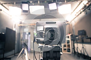 Film camera in broadcasting studio, spotlights and other equipment