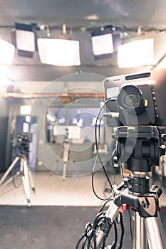 Film camera in broadcasting studio, spotlights and other equipment