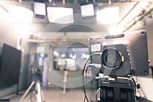 Film camera in broadcasting studio, spotlights and other equipment