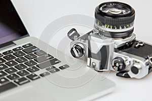 Film camera with lens and a laptop