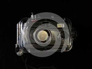 Film camera in a waterproof case, on a black background. Digital camera in a protective case. Equipment for underwater photography