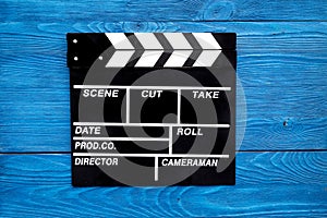 Film concept. Clapperboard on blue wooden background top view copyspace