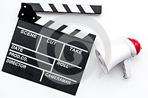 Film director, producer concept. Filming. Electronic megaphone and clapperbord on white background top view