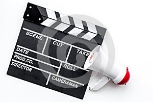 Film director, producer concept. Filming. Electronic megaphone and clapperbord on white background top view