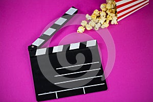 Film flap with popcorn on a pink background