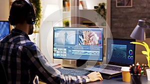 Film maker pointing at the monitor in home office