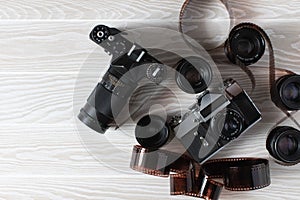 Film old cameras with lenses and manifested film on a white background with copy space.
