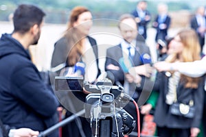 Filming an media event with a video camera. Press conference.