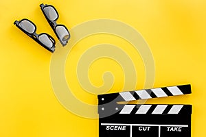 Filmmaker accessories. Clapperboard and glasses on yellow background top view copyspace