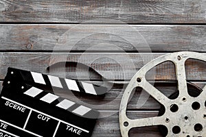 Filmmaker profession with clapperboard and video tape on wooden background top view copyspace