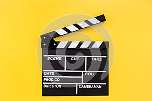 Filmmaker profession. Clapperboard on yellow background top view copyspace