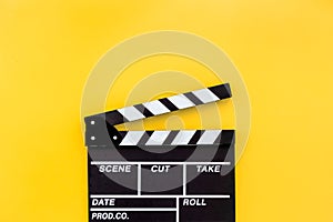 Filmmaker profession. Clapperboard on yellow background top view copyspace