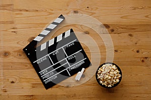 Filmmaking concept. Movie Clapperboard. Cinema begins with movie clappers. Movie clapper on an old wooden background and popcorn